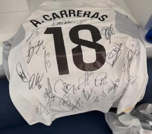卡雷拉斯完成皇马首秀后，让队友们在球衣上给他签名做纪念
